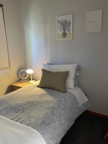 - une chambre avec un lit et un oreiller dans l'établissement Daisy House - Whittington - 10 minutes to central Geelong, 