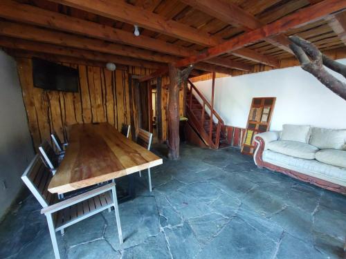 sala de estar con mesa de madera y sofá en grandes cabañas 2 en Pucón