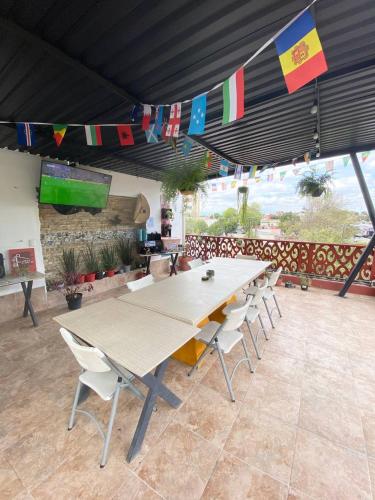 a large table and chairs in a room with flags at Hostal Talavera in Puebla