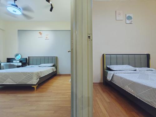 two beds in a room with wooden floors at INS Pavillion by irainbow in Ipoh