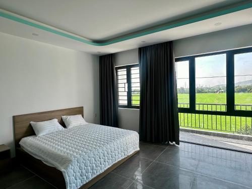 a bedroom with a bed and a large window at Ruby Motel Bà Rịa in Ba Ria
