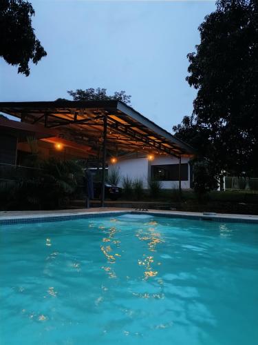 a swimming pool at night with a pergola at Casa Mangos in Orotina