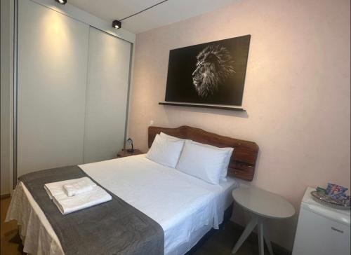 a small bedroom with a bed and a table at Kim Casa BH in Belo Horizonte