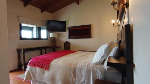 a bedroom with a bed and a flat screen tv at Hotel Casa Puccllana in Constitución