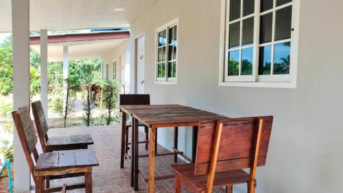 a wooden table and chairs in a room at ปารมีฟาร์มสเตย์ in Ban Chao Nam