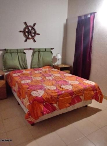 a bed with a colorful comforter in a room at Chalet Arena Malva in San Bernardo