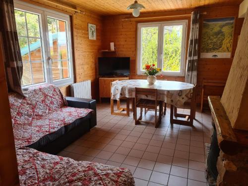 un salon avec une table et un canapé dans l'établissement Chalet confortable avec cheminée proche de La Bresse-Hohneck, idéal pour famille et amis. - FR-1-589-123, à La Bresse