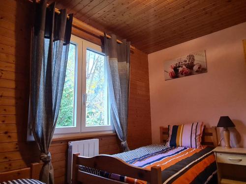 ein Schlafzimmer mit einem Bett und einem Fenster in der Unterkunft Chalet Confortable à La Bresse, Proche Ski, Wifi, Animaux Acceptés - FR-1-589-130 in La Bresse