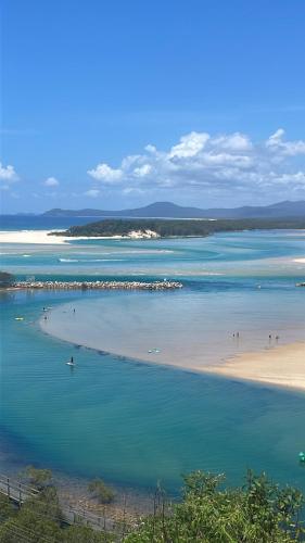 a view of a beach with people in the water at Spectacular Sol y Mar @ Nambucca Heads in Nambucca Heads