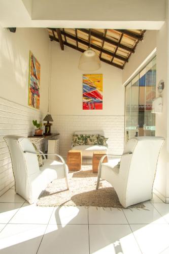 a living room with two white chairs and a couch at Hotel Latitud Buzios by Latitud Hoteles in Búzios