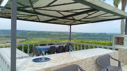 a patio with a table and chairs on a balcony at Finca Maratón Alto in Calarcá