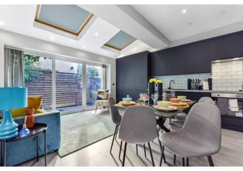 a kitchen and dining room with a table and chairs at Three Bedroom Home - Perfect for Large Groups in London
