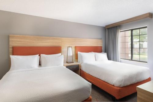 a hotel room with two beds and a window at Candlewood Suites Eagan - Mall of America Area by IHG in Eagan