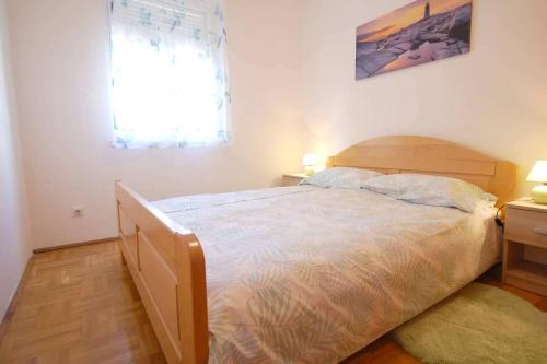 um quarto com uma cama grande e uma janela em Apartments with a parking space Njivice, Krk - 21866 em Njivice