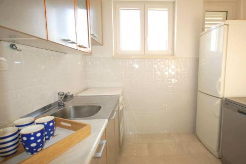 uma pequena cozinha com um lavatório e um frigorífico em Apartments with a parking space Njivice, Krk - 21866 em Njivice