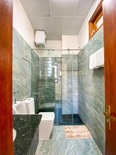 a bathroom with two toilets and a glass shower at Duy Thảo Hotel in Da Lat