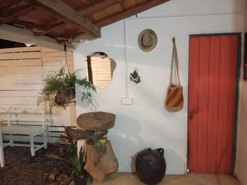 Habitación con pared blanca y puerta roja en Casa Betania, entorno natural, en Páramo