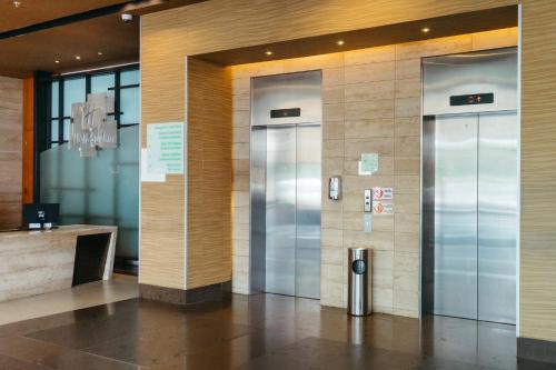 two elevators in a lobby of a building at Holiday Inn Guayaquil Airport by IHG in Guayaquil