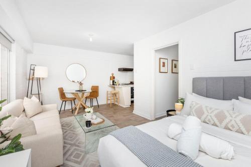 a white living room with a couch and a table at Urban Chic Studio by 'the Strip' in Perth