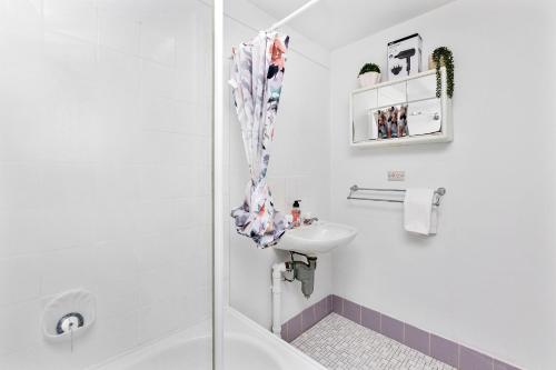 a white bathroom with a sink and a shower at Urban Chic Studio by 'the Strip' in Perth