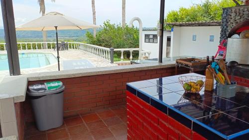 a counter top with a trash can and an umbrella at Finca Maratón Alto in Calarcá