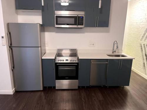 uma cozinha com um frigorífico de aço inoxidável e micro-ondas em Beautiful 1 BR Art DECO Inspired em Filadélfia