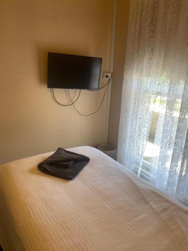 Commercial Hotel Camperdown في كامبرداون: غرفة نوم مع سرير وتلفزيون بشاشة مسطحة على الحائط