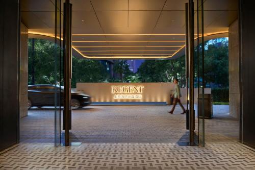 a woman walking through a entrance to a building at Regent Shanghai on the Bund in Shanghai