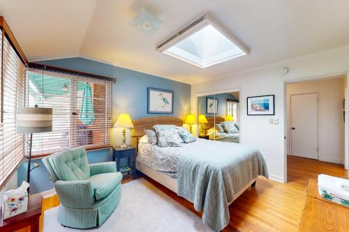 a bedroom with a bed and a chair and a window at Butterfly Landing in Pacific Grove