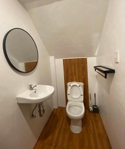 a bathroom with a sink and a toilet and a mirror at JaL GUESTHOUSE in Legazpi