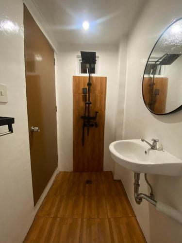 ein Bad mit einem Waschbecken und einem Spiegel in der Unterkunft JaL GUESTHOUSE in Legazpi