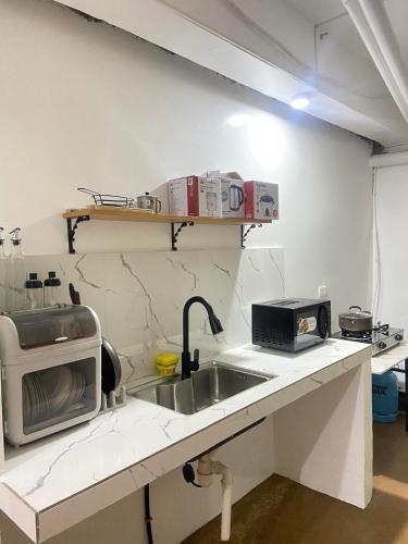 una cocina con fregadero y microondas en una encimera en JaL GUESTHOUSE, en Legazpi