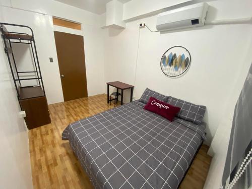 Dormitorio pequeño con cama con almohada roja en JaL GUESTHOUSE, en Legazpi