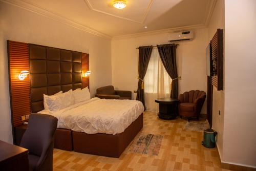 a bedroom with a bed and a living room at Abada Luxury Hotel and Suites in Onitsha