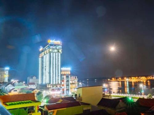 a city skyline at night with a tall building at Diamond Hotel Quảng Bình in Dong Hoi
