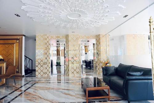 a living room with a couch and a chandelier at B.O.B HOTEL SIGNATURE in Cao Lãnh