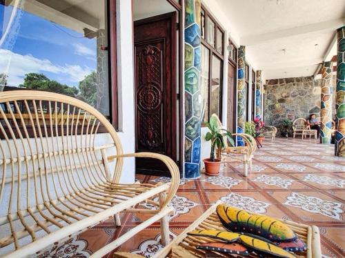 a porch with two benches on a house with a tile floor at Casa Don Clemente in San Pedro La Laguna