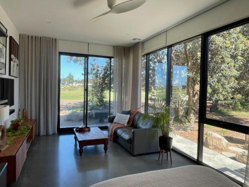 a living room with a couch and large windows at Tanderrum Guest Suite in Point Lonsdale
