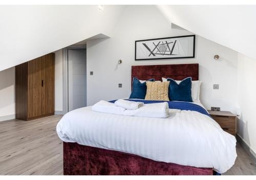 a bedroom with a large bed with blue pillows at Cozy and Stylish 2 BR flat in Greater London in London