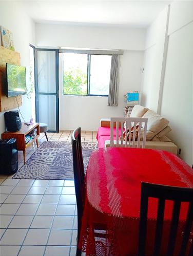 a living room with a red table and a couch at Apto aconchegante in Cabedelo