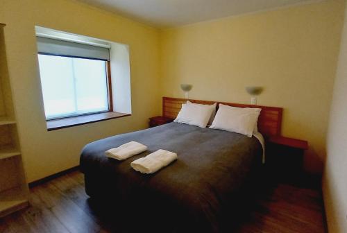 a bedroom with a bed with two towels on it at Cumbres Nevadas in Coihaique