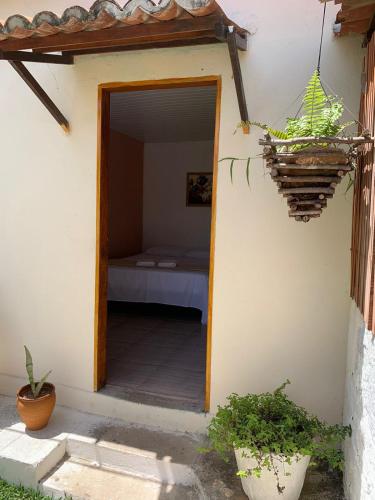 una entrada a un dormitorio con cama en una casa en Suíte Nativa - Flecheiras en Flecheiras