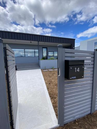 a garage with a gate and a house at The Beach House @ Primrose Sands in Primrose Sands