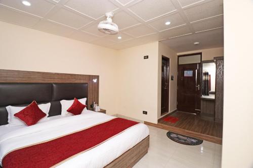 a bedroom with a large bed with red pillows at Hotel O Abc Residency in Srīnagar