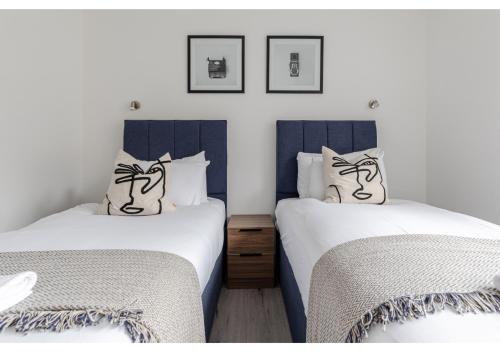 two beds sitting next to each other in a bedroom at Simply Perfect 2BR 2BT Apartment in London