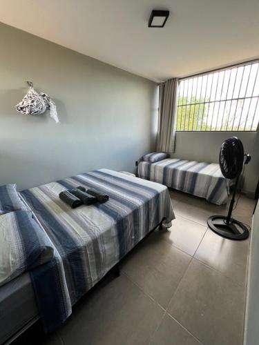 a bedroom with two beds and a fan at Casa em Monte das Gameleiras-RN in Monte das Gameleiras