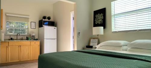 a bedroom with a bed and a refrigerator and a sink at Loft Close to Downtown, Raymond James Stadium, Airport and Many More Places in Tampa