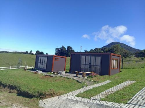 Deux petites maisons dans un champ avec une montagne en arrière-plan dans l'établissement Monte Santa Lucia, 