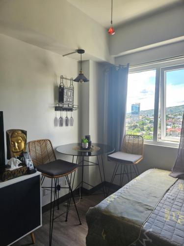 um quarto com uma cama, uma mesa e cadeiras em E Staycation Studio em Cebu