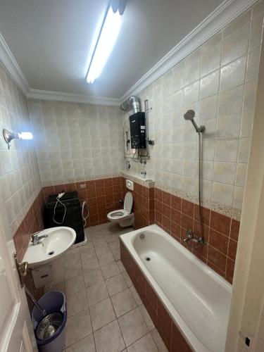 a bathroom with a tub and a sink and a toilet at كمباوند الخليج in Cairo